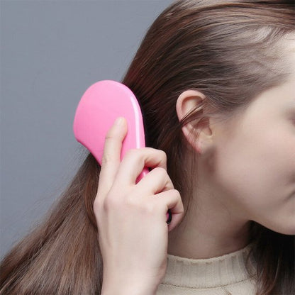 Brosse à cheveux brosse rose a la main