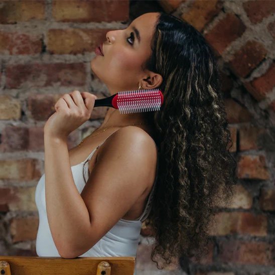 Brosse à cheveux fille regarde vers le haut avec sa brosse