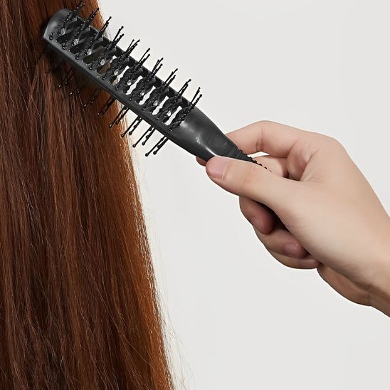 Brosse cheveux bouclés main tien la brosse