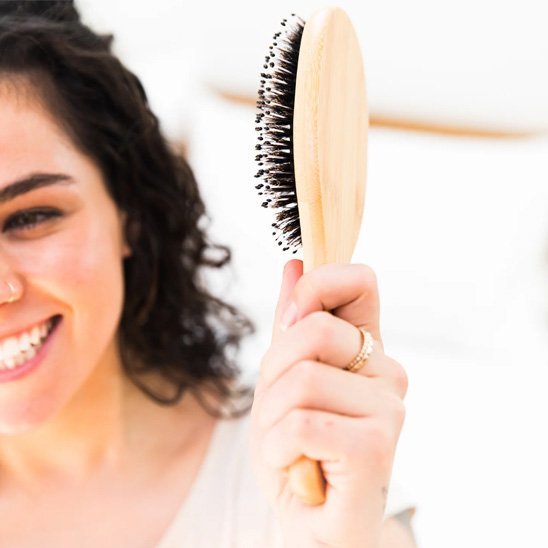 Brosse en poil de sanglier dans la main